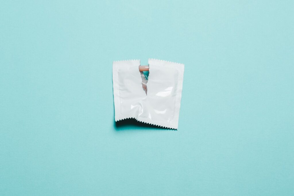 Angerissenes Kondom-Päckchen vor neutralem Hintergrund