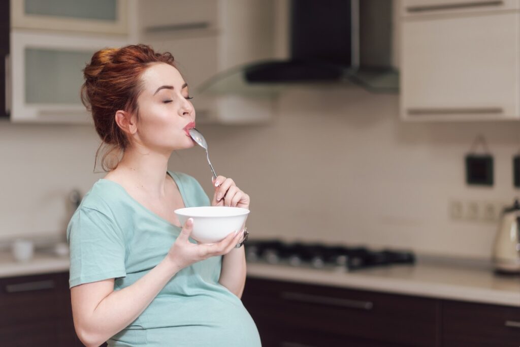 Schwangere Frau, die ihr Essen geniesst