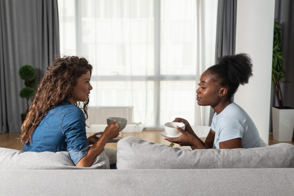 Zwei junge Frauen in Gespräch auf der Couch