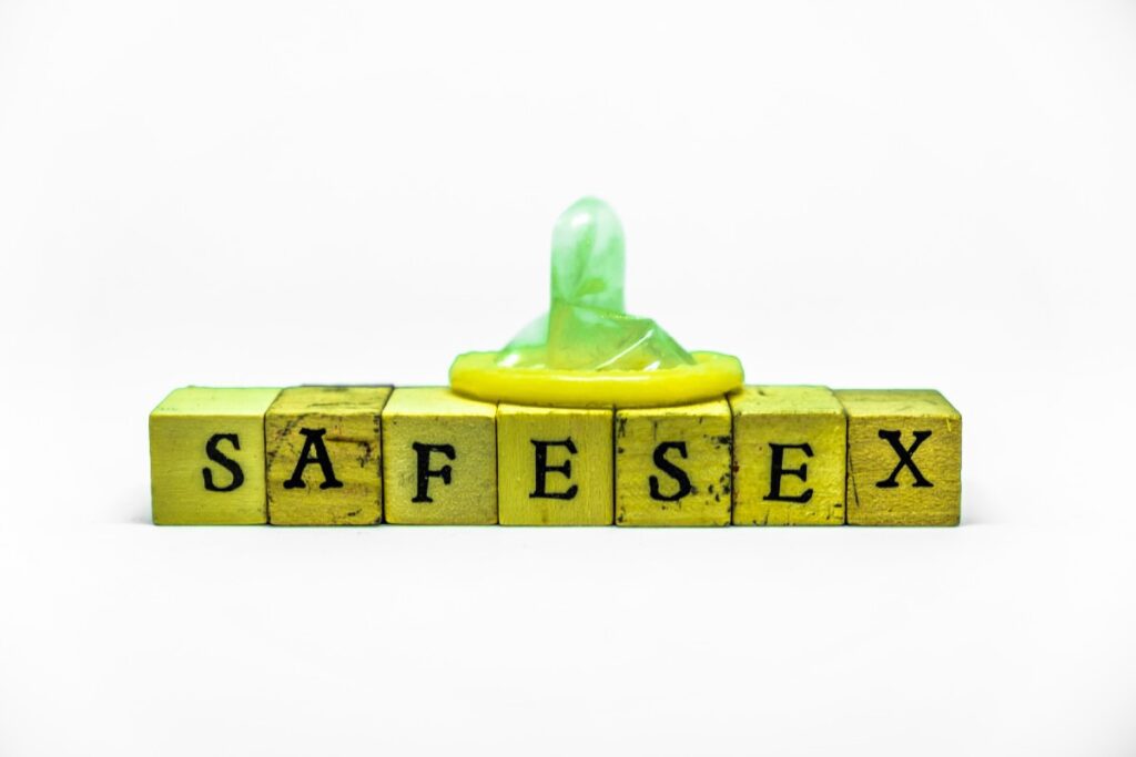 Wortklötze, die das Wort "Safersex" bilden, mit einem Kondom auf ihnen