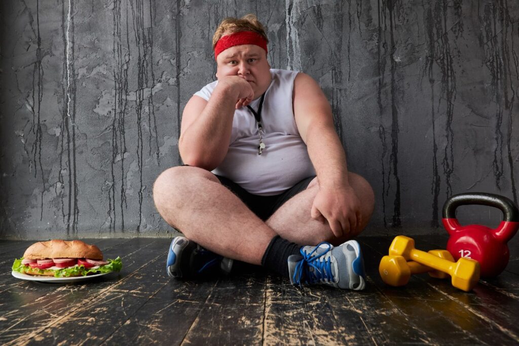 Übergewichtiger Mann, traurig in Trainingsmontur