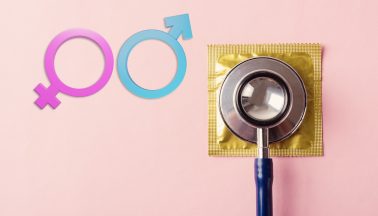Die Zeichen für Männlichkeit und Weiblichkeit neben einem Kondom mit Stethoskop