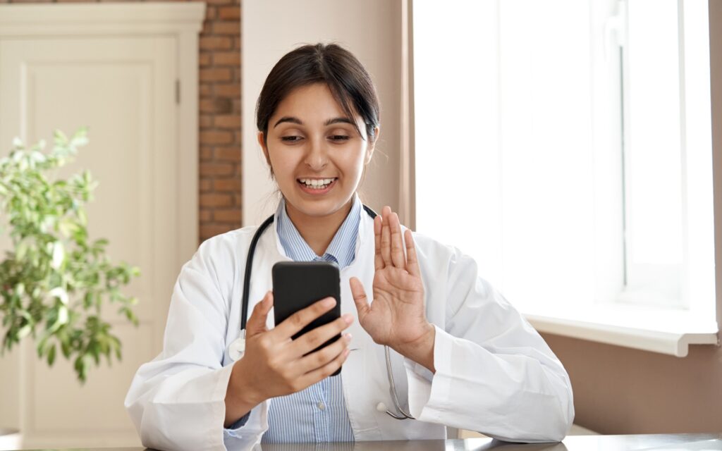 Junge Ärztin, die in ihr Handy schaut