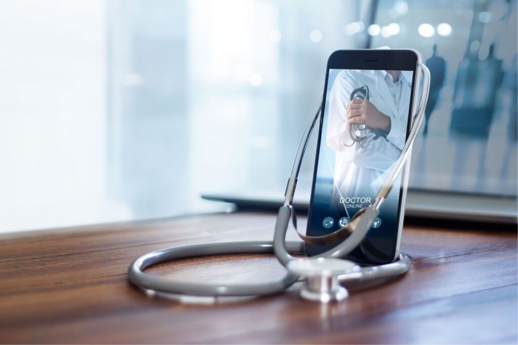 Handy mit dem Bild eines Arztes auf dem Schirm und Stethoskop