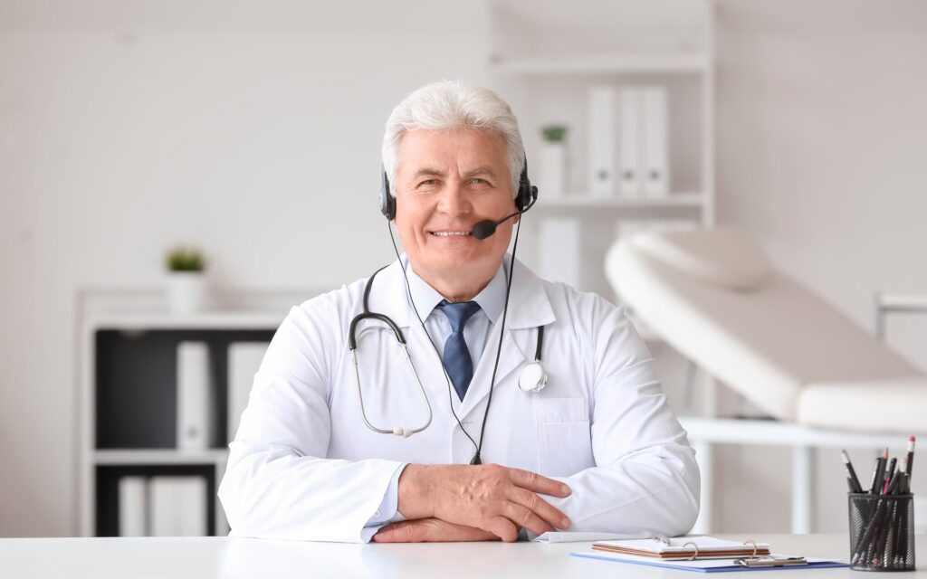 Älterer Arzt mit Headset