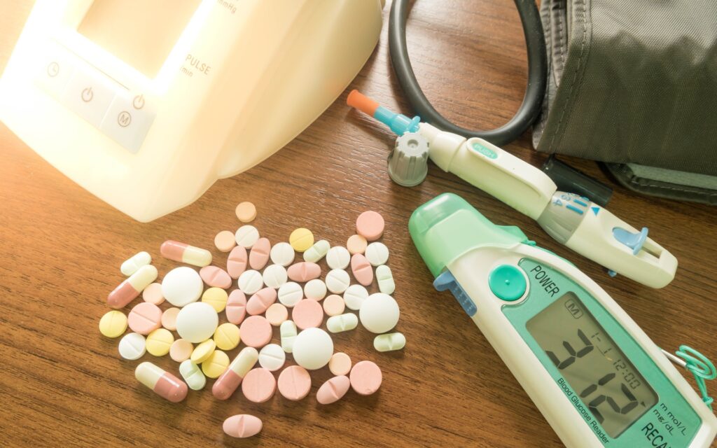 Blutdruckmessgerät und Pillen auf einem Tisch