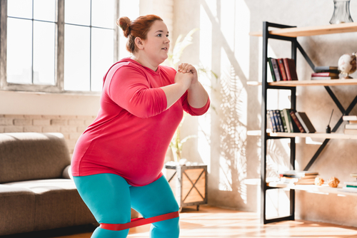 Femme en surpoids faisant des exercices physiques à domicile pour accompagner sa perte de poids avec un traitement GLP-1