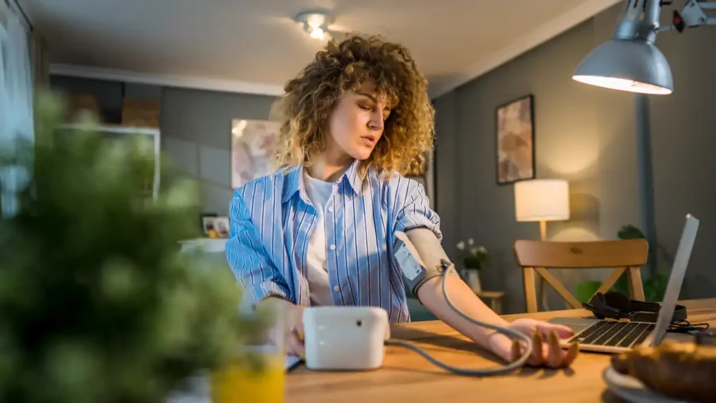 Junge Frau misst Blutdruck