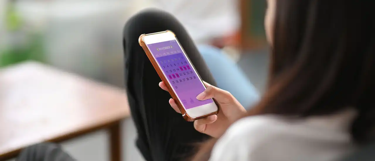 Frau mit Zyklus-App auf dem Smartphone