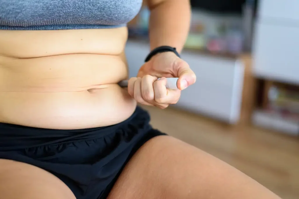 Junge Frau spritzt sich in den Bauch