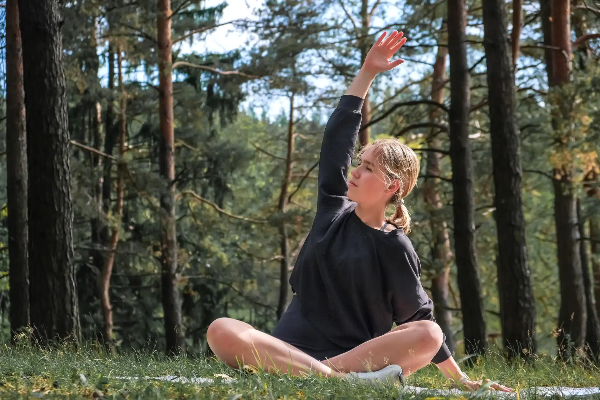 Junge Frau macht Yoga im Wald