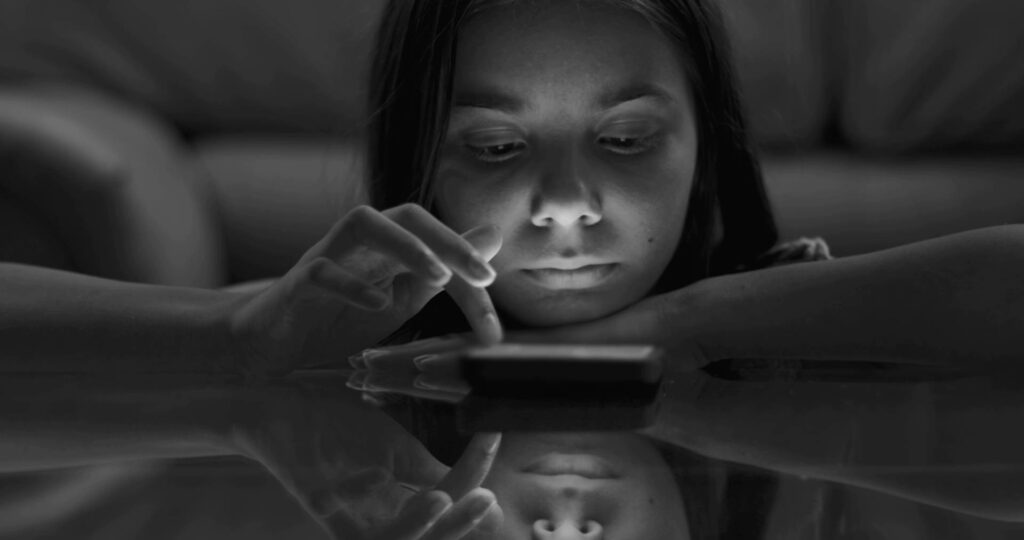 Schwarzweiss junge Frau an ihrem Handy