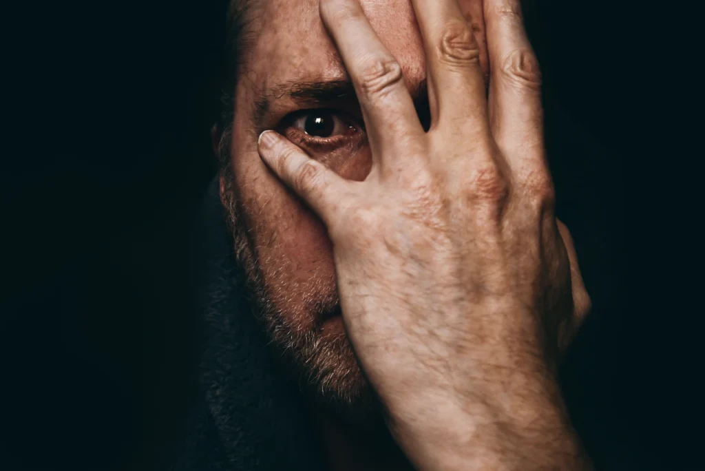 Mann hält sich erschüttert die Hand vors Gesicht