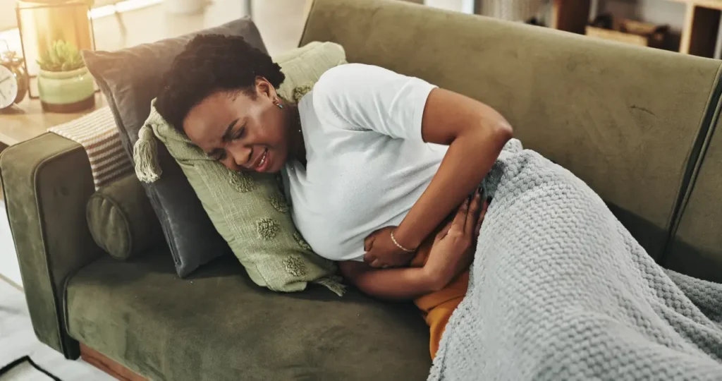Frau mit Schmerzen auf der Couch