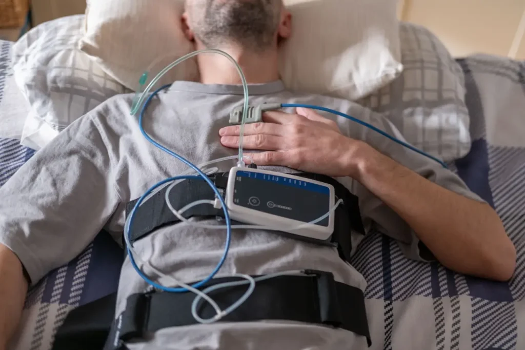 Mann mit Messgerät im Bett