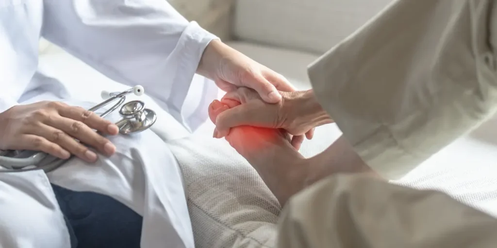 Ärztin untersucht den Fuss ienes Patienten