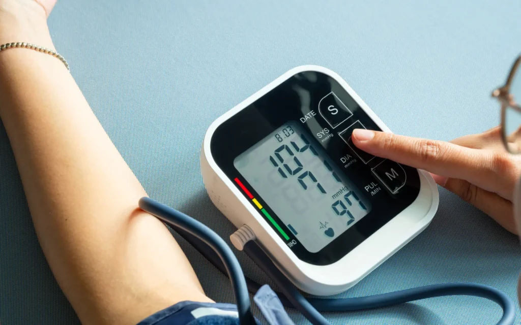 Frau misst ihren Blutdruck mit Oberarmmanschette