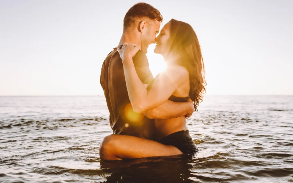 Paar im Abendsonnenschein zusammen im Wasser am Strand
