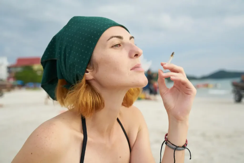 Junge Frau mit Joint am Strand