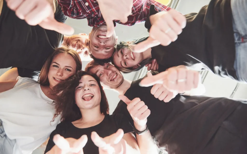 Gruppe junger Menschen schaut von oben in die Kamera