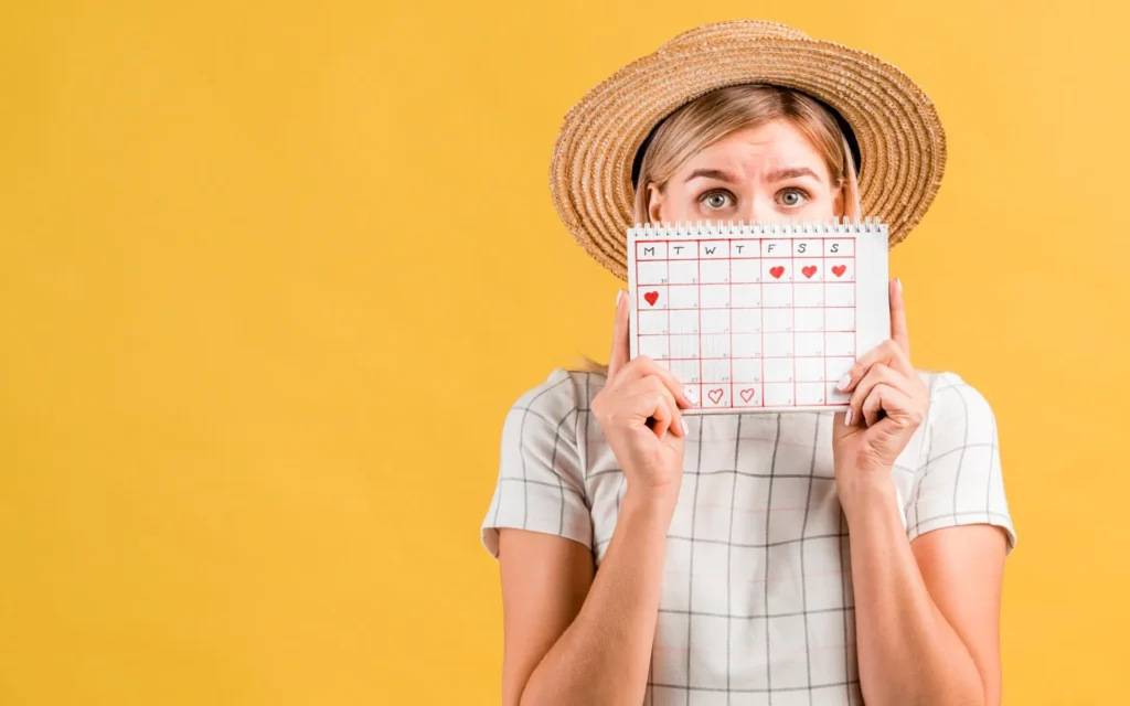 Junge Frau schaut über einen Kalender