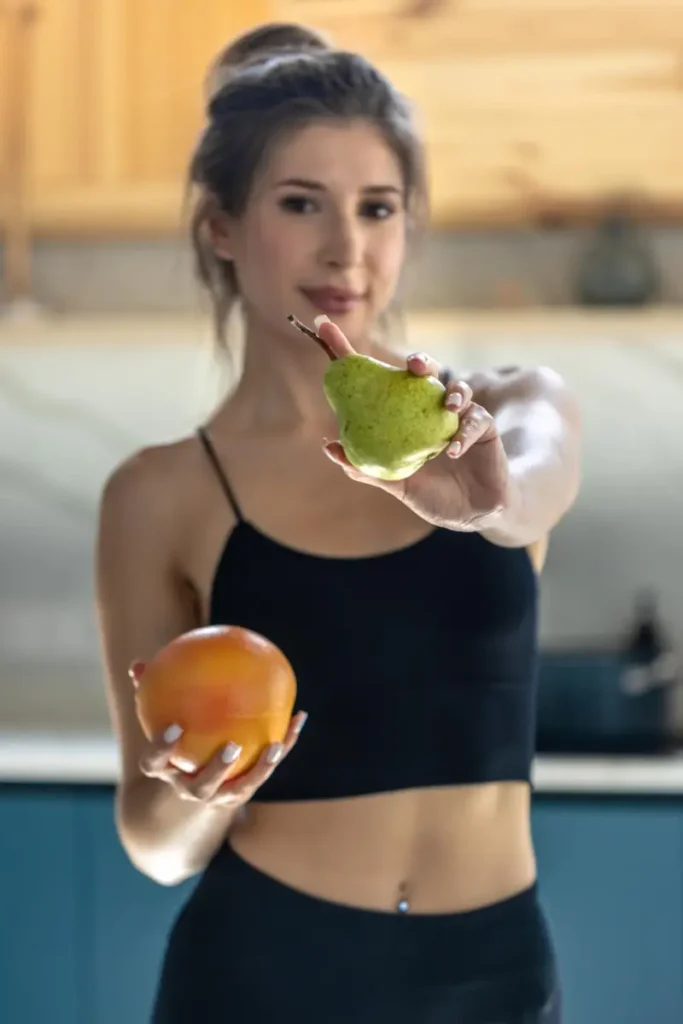 Junge sportliche Frau mit Obst in der Hand