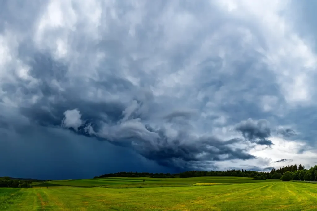 Dunkle Gewitterwolken ziehen über eine Landschaft und zeigen einen abrupten Wetterumschwung.
