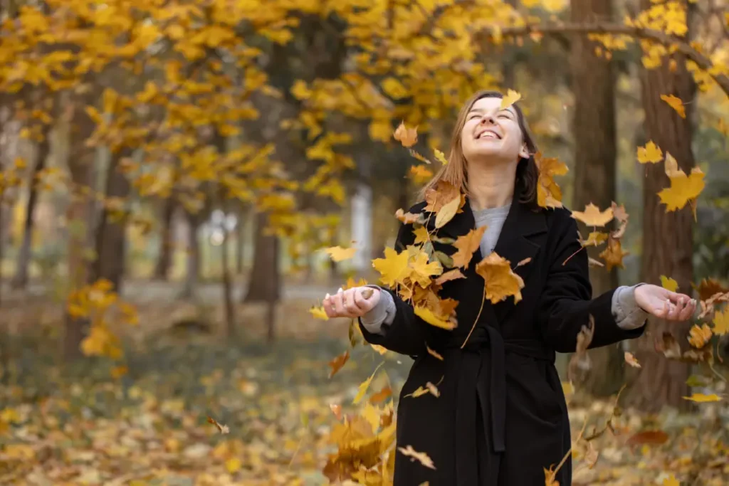 Junge Frau geniesst den Aufenthalt im herbstlichen Wald