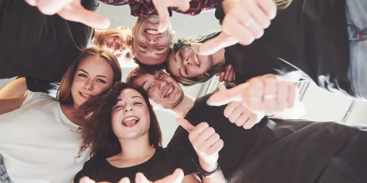 Gruppe junger Menschen schaut von oben in die Kamera