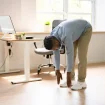 Mann dehnt sich neben Büroschreibtisch