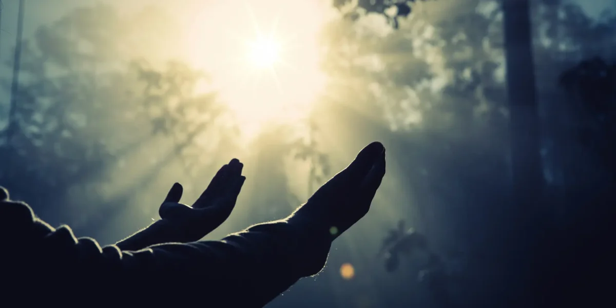 Zwei Hände über denen die Sonne scheint