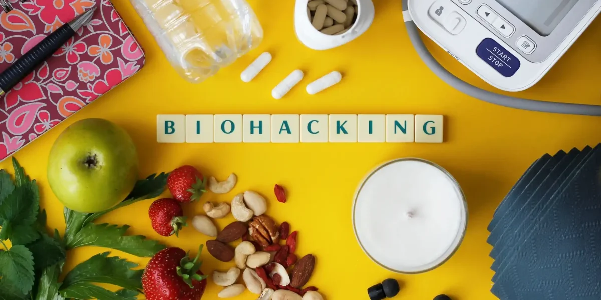 Schriftzug Biohack auf Würfeln, umgeben von Nahrungsmitteln