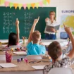 Kinder in einer Schulklasse melden sich