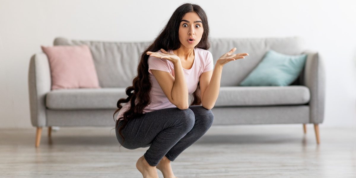 Überraschte junge Frau auf Waage