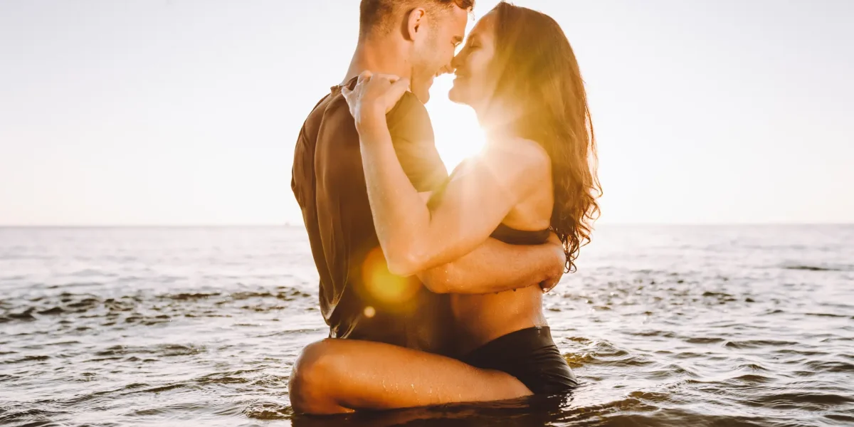 Paar im Abendsonnenschein zusammen im Wasser am Strand