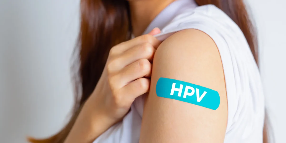 Frau mit einem Pflaster auf dem Oberarm mit dem Schriftzug HPV