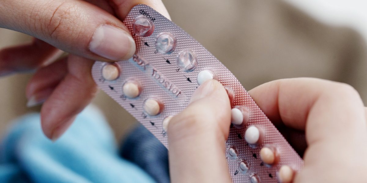 Frauenhände, die eine Blisterverpackung mit der Pille halten