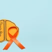 Gehirn aus Papier mot orangenfarbener Schleife erinnern an Multiple Sklerose Awareness