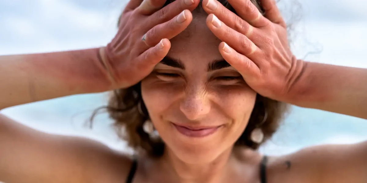 Junge Frau ist gestresst und hält sich die Hände an den Kopf