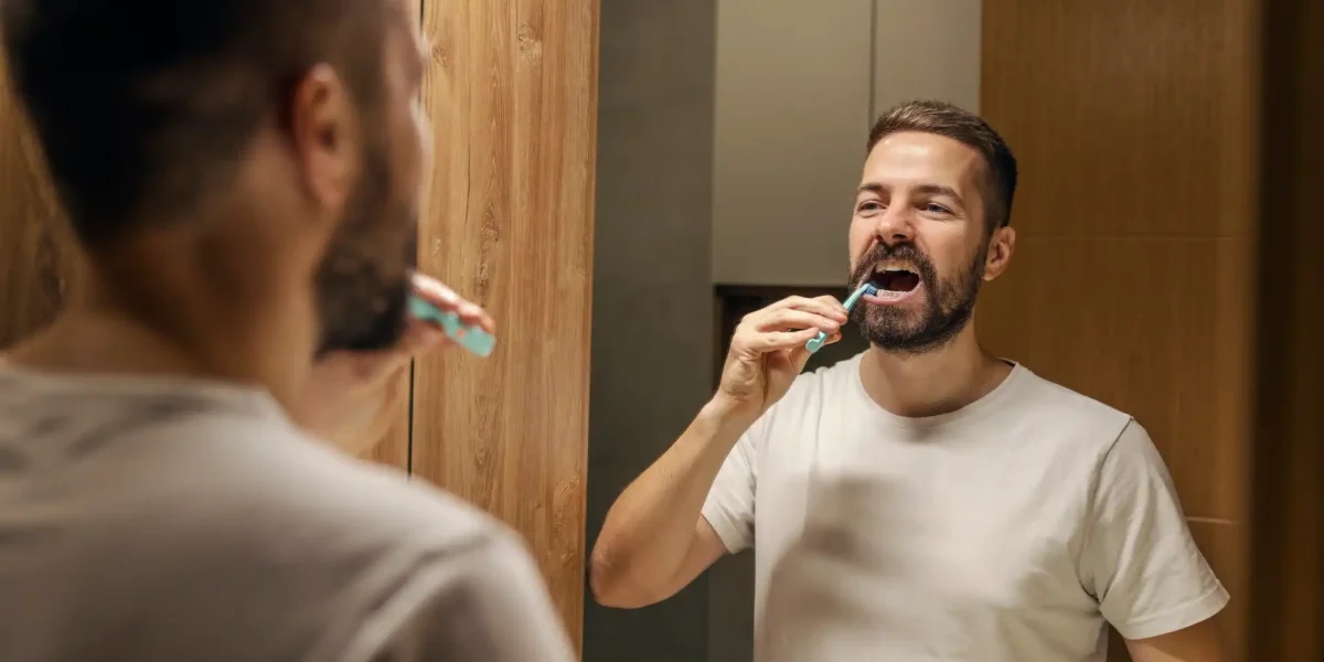 Mann Zähneputzen Spiegel