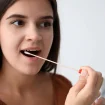 Junge Frau nimmt Speicheltest