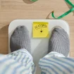 Person steht auf Waage
