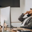 Mann sitzt erschöpft und gelangweilt an seinem Arbeitsplatz im Büro