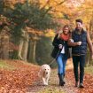 Paar mit Hund bei einem Waldspaziergang
