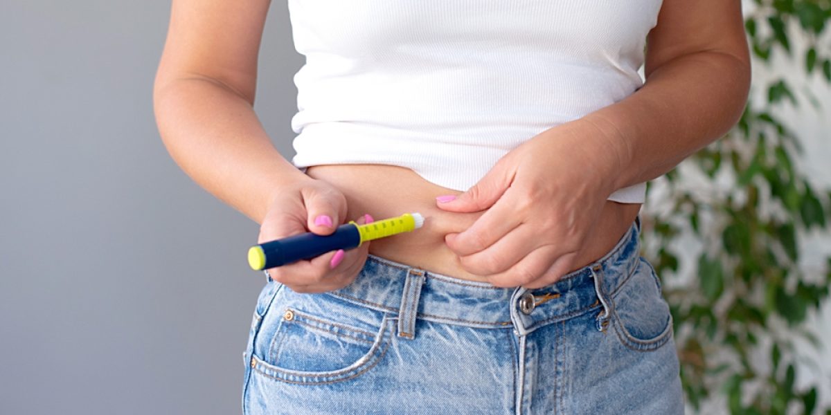 Femme se préparant à faire une auto-injection de traitement GLP-1 à domicile pour la perte de poids et le bien-être